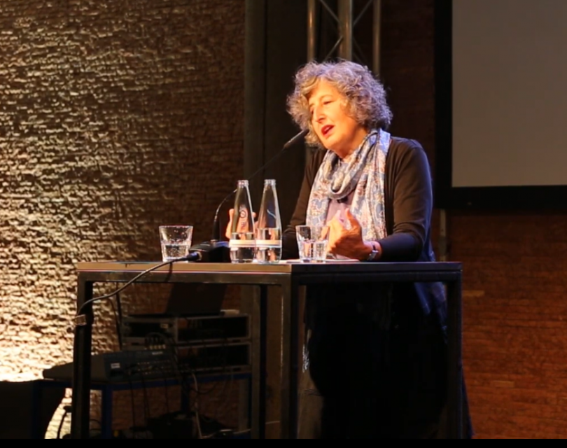 a professor sits at a table.